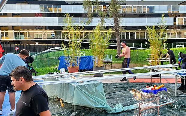 Des habitants montent ensemble les structures en bois de la place, octobre 2022
