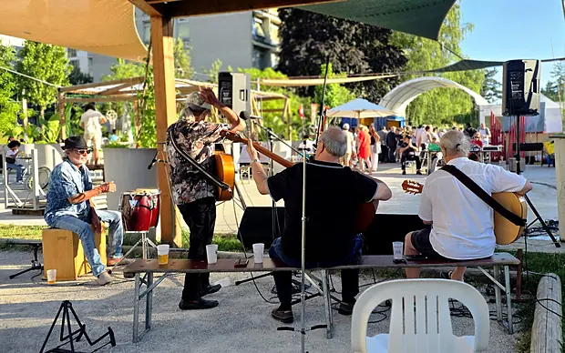 Un groupe de musiciens joue sous la pergola de la place de la Tambourine, mai 2026